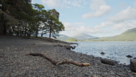 panning shot of english lake in cumbria, beach in foreground