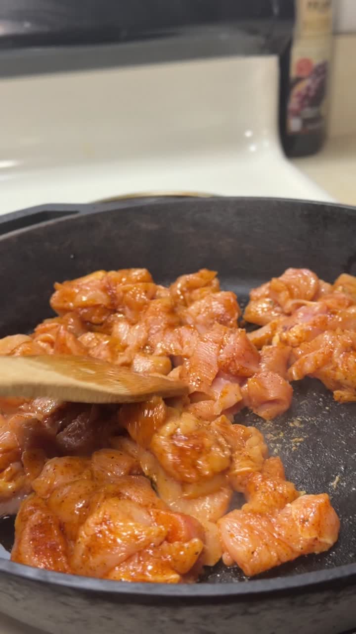 Primo piano di pollo che cuoce in padella di ghisa in modo invitante.
