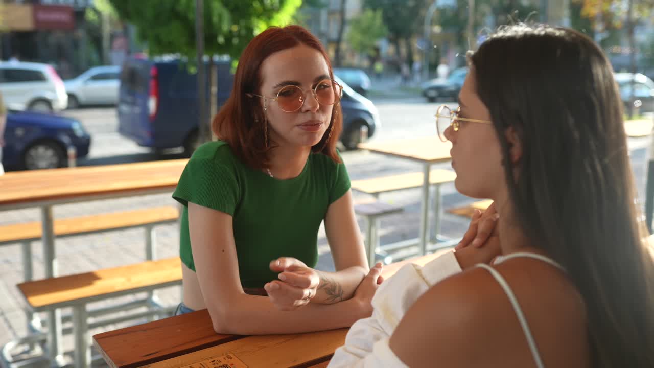 dos amigas que tienen una conversación en un café al aire libre