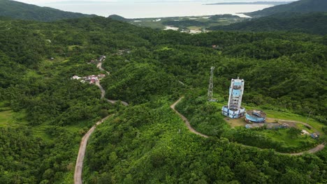 aerial forward shot of doppler weather radar station atop lush tropical mountains overlooking province catanduanes, philippines