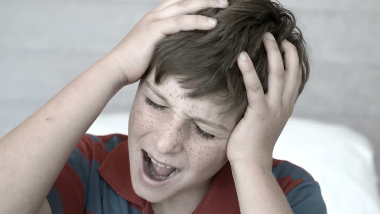 손 사이 에 머리 를 고 있는 짜증 난 소년