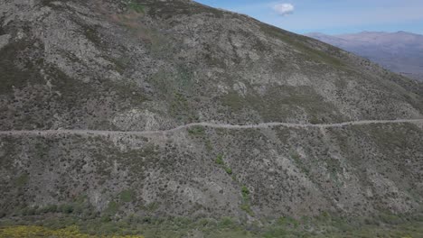 flight with a drone where we see a mountain road and circulating a line formation of bikers we appreciate the great volume of the slope and a valley in the background in sierra de gredos avila spain