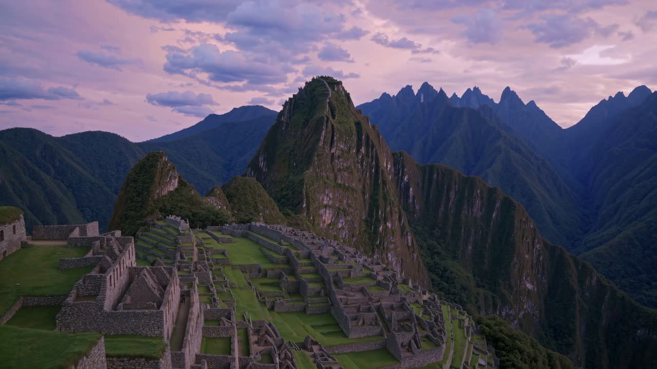 Aerial view of Machu Picchu at sunset, showcasing ancient ruins and dramatic mountain backdrop