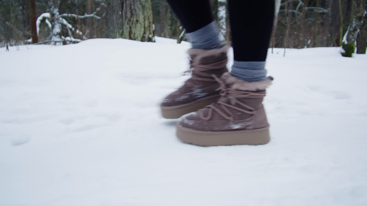 Mujer caminando en un bosque cubierto de nieve