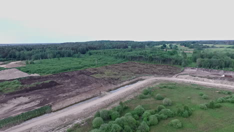 aerial shot of deforestation in a lush green area on a grey day