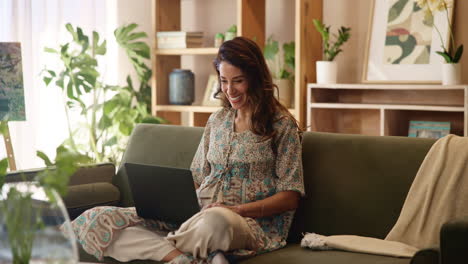mujer trabajando desde casa en una computadora portátil