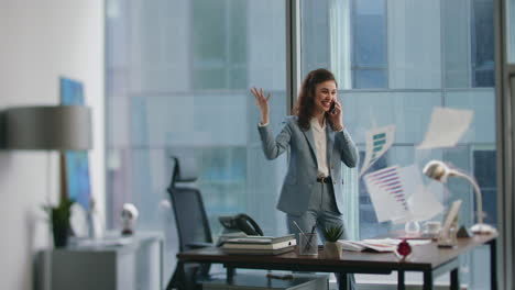 businesswoman rejoicing victory calling at office. happy woman throwing papers