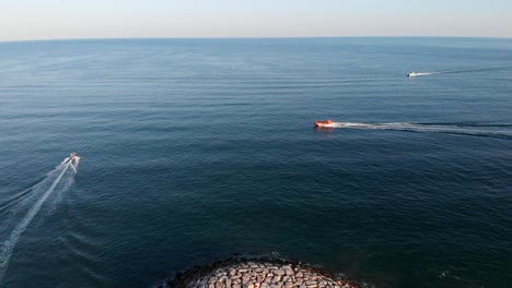 Aerial-view-of-sailing-two-luxury-yacht-on-high-speed-during-sunset-in-Albufeira,-Portugal