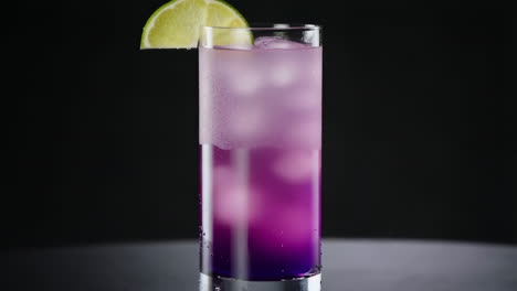 vibrant layered purple drink with lime garnish