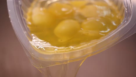 eggs being poured from a plastic container