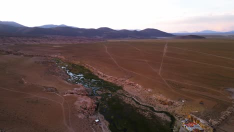 Un-Arroyo-Serpenteante-En-El-Vasto-Y-árido-Paisaje-De-Chile-Al-Atardecer,-Vista-Aérea