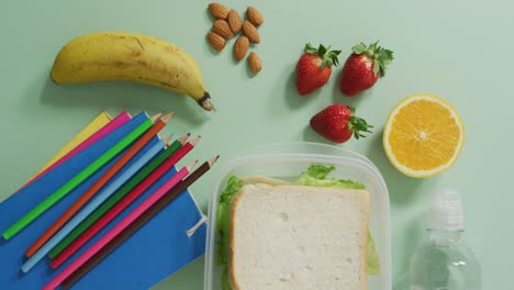 video of healthy packed lunch of fruit and vegetables, with coloured pencils and notebooks