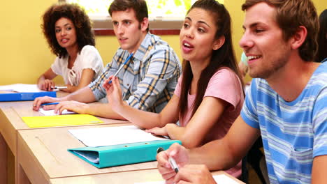 Estudiantes-Sentados-En-Fila-Escuchando-En-El-Aula