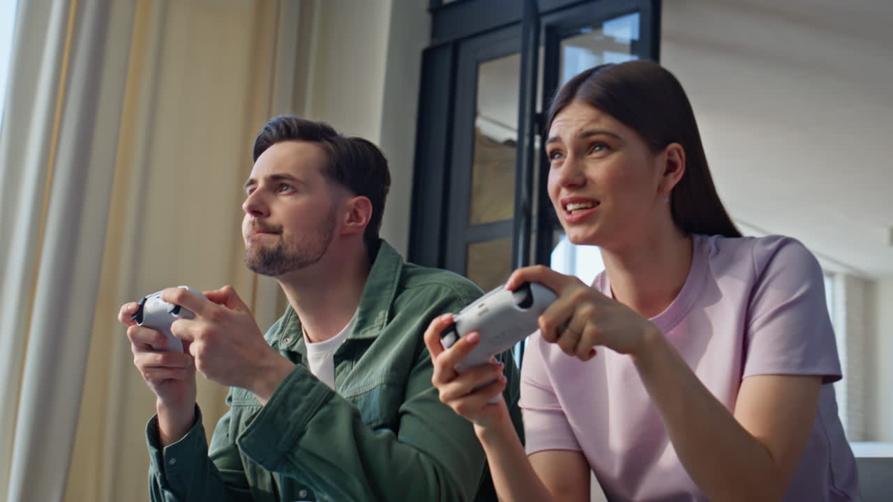 Young couple playing online at home sofa closeup. Video players modern hobby