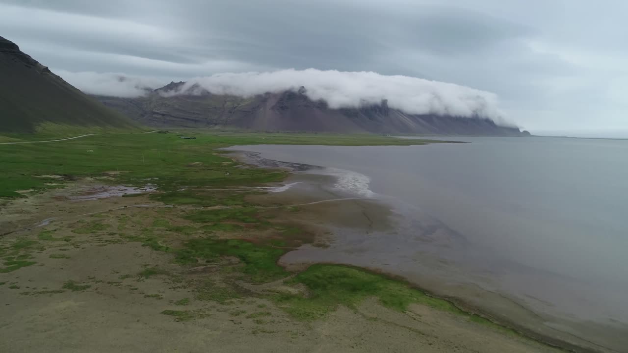 구름과 안개가 맨 위로 굴러가는 아이슬란드의 놀라운 아름다운 피요르드의 놀라운 공중 샷