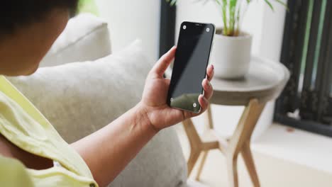 Video-of-hands-of-plus-size-african-american-woman-with-smartphone-with-copy-space-on-screen