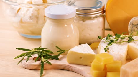 various cheeses and dairy items on wooden board