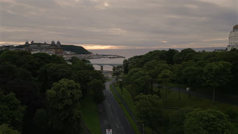 Eine-Drohne-Schoss-Bei-Bewölktem-Sonnenaufgang-Die-Talstraße-In-Scarborough-Hinunter-Zum-Strand