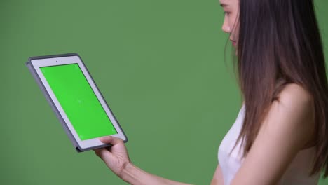 joven y hermosa mujer de negocios asiática mostrando una tableta digital