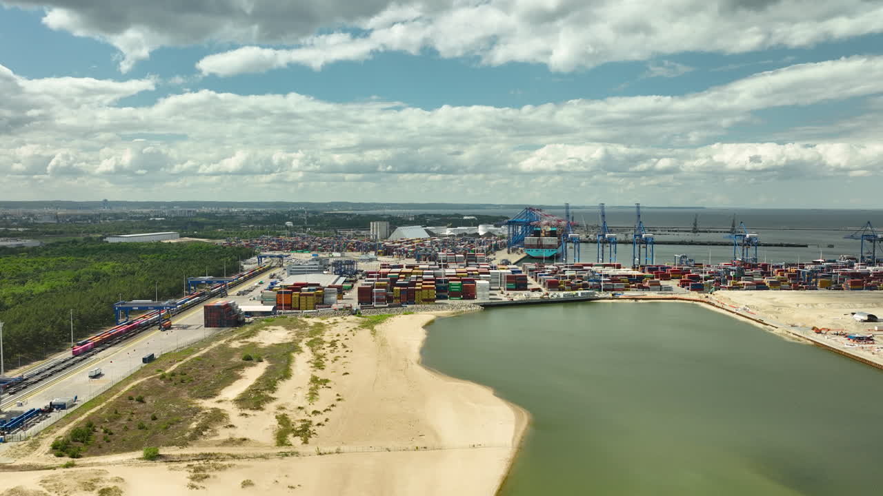Aerial view of the Port of Gdańsk, highlighting Stogi Beach, industrial cranes, and shipping containers, illustrating the dynamic interface between industry and nature