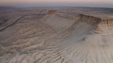 aerial view of a desert cliff face at sunrise/sunset.