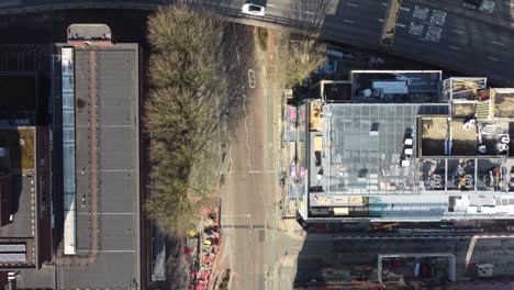 aerial drone flight giving a birdseye view of oxford road and the mancunian way flyover during lockdown showing the empty streets and rooftops below