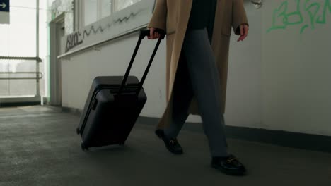 woman walking with suitcase in airport terminal