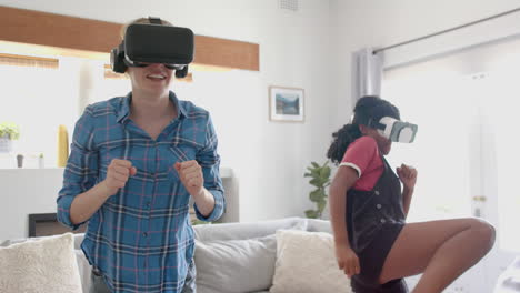 Happy-diverse-teenage-female-friends-playing-and-wearing-vr-headsets-at-home,-slow-motion