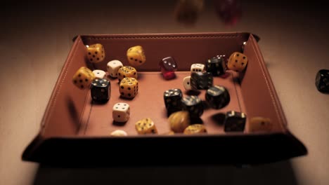 Many-multicoloured-dice-falling-into-a-dice-tray