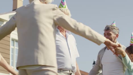 family dancing around grandfather on birthday party
