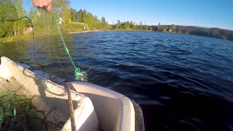 tirando de una red de pesca en un pequeño lago en noruega
