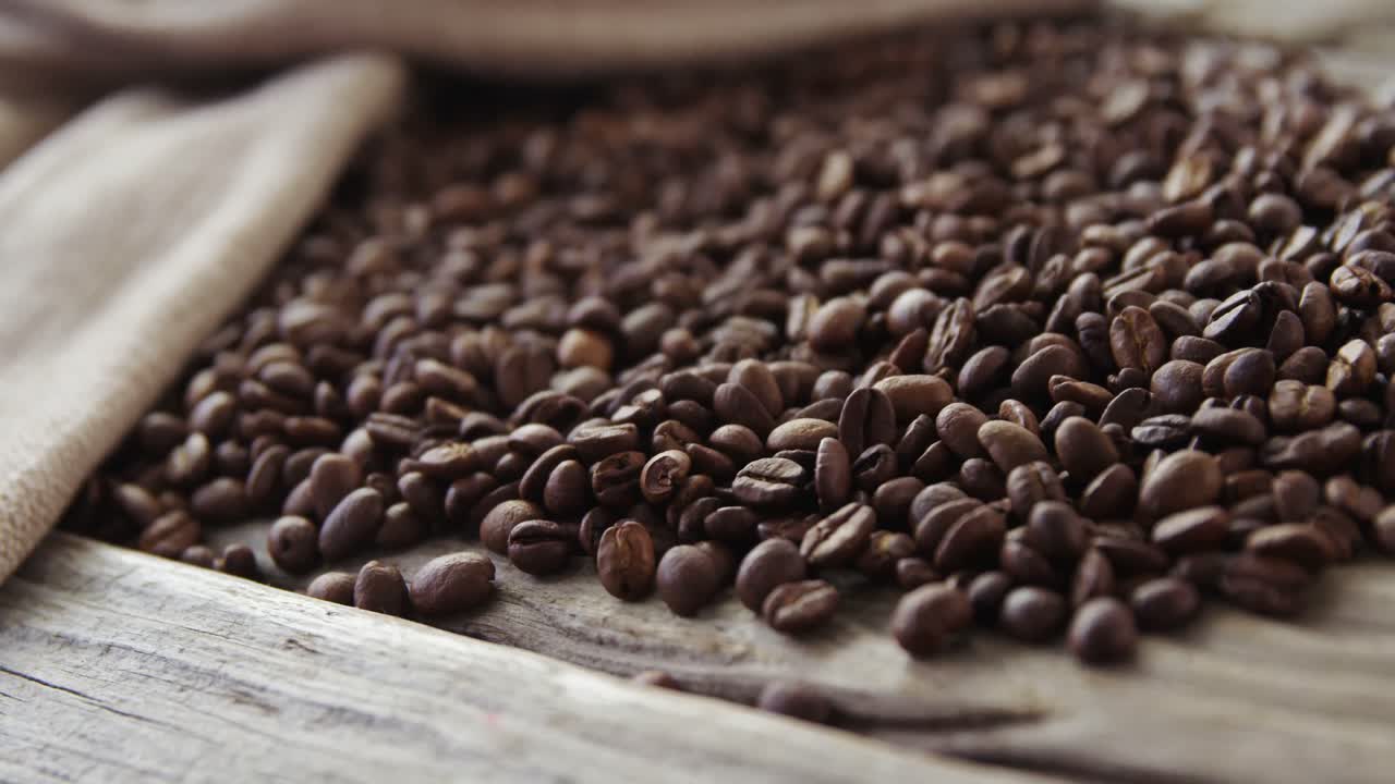 Coffee beans falling on wooden plank