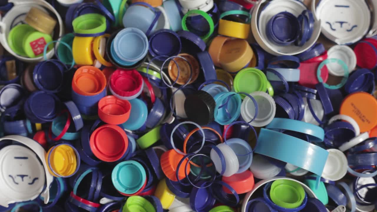 손으로 작은 병뚜껑 더미를 잡고 더 큰 더미로 다시 던집니다.