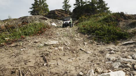 rc truck going down a rocky hill during day time