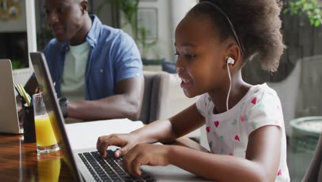 video of african american father and daughter using laptop and learn