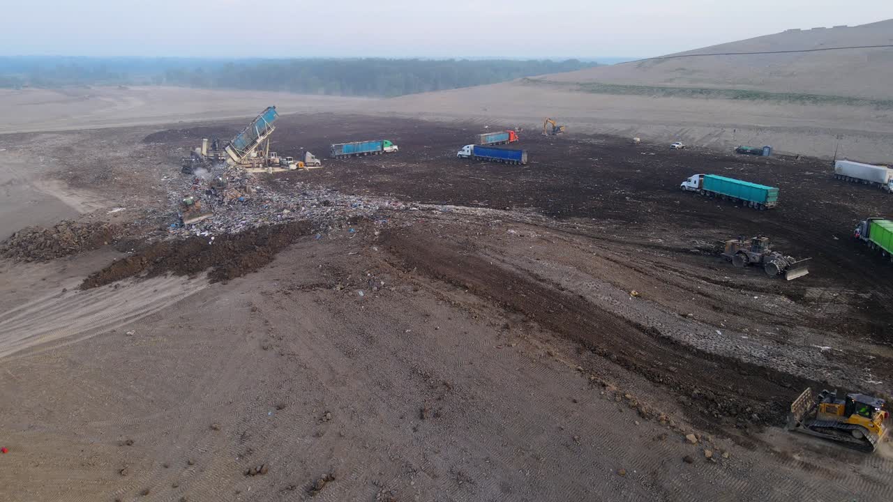 Landfill site with trucks unloading waste in a large open area, Michigan, USA, garbage and refuse from Canada is shipped to Michigan