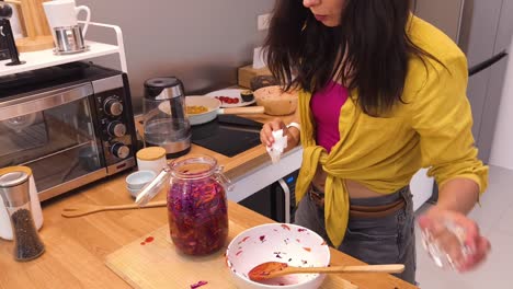 mujer haciendo repollo rojo fermentado en la cocina