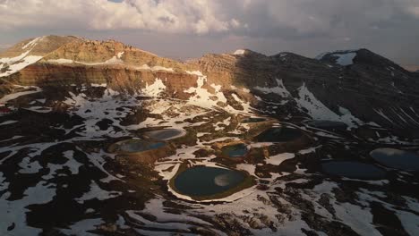 dramatic aerial pull back view of the akoura lakes at glowing sunset, lebanon