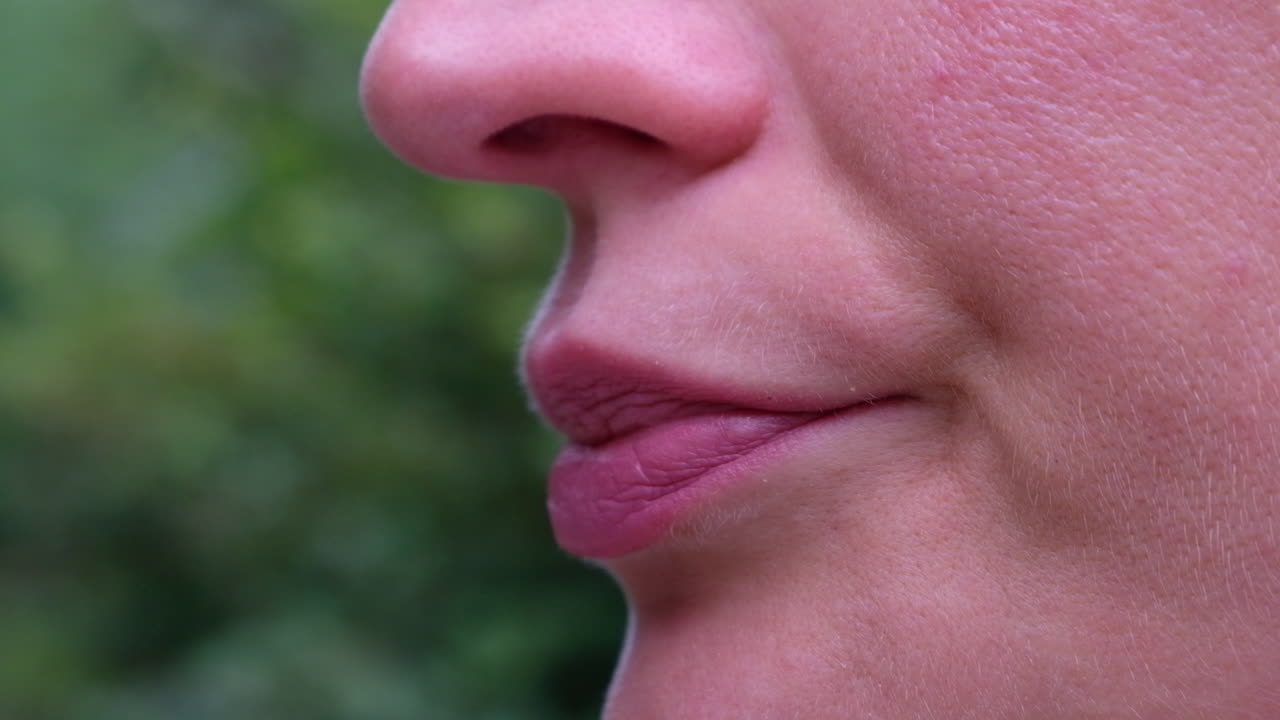 Close up of a woman blowing her nose in the park