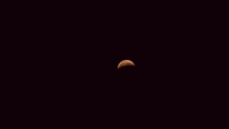 beautiful time lapse of a lunar eclipse traveling across a night, black sky. a total lunar eclipse occurred on 26 may 2021.