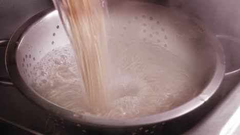 pouring noodles and boiling water into strainer, cooking japanese food