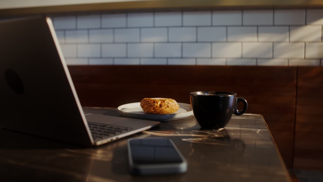 Notebook, Café e um Doce em um Café