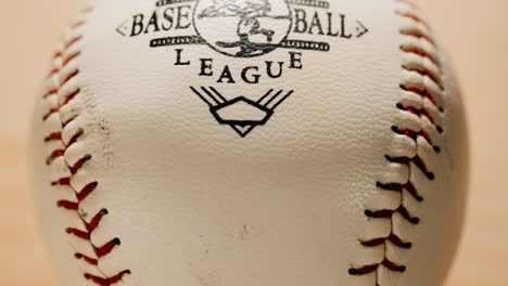 dirty used official baseball league ball rotating close up with bright warm background