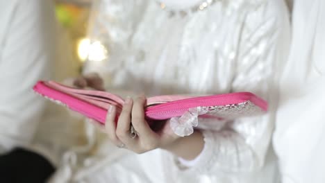 young traditional muslim woman reading quran on the mosque before iftar dinner during a ramadan feast at home