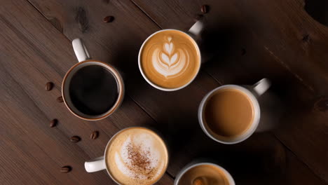 assortment of coffee drinks on a wooden table with coffee beans