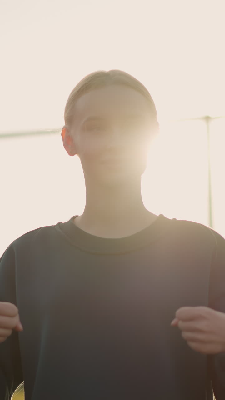 세 명의 젊은이들이 피트니스 활동을 하며, 빛이 그 주변에 빛나고, 바 울타리, 초록색, 그리고 배경에 보이는 축구장