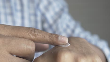 man applying beauty cream onto skin