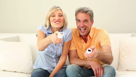 husband and wife playing video games on the couch