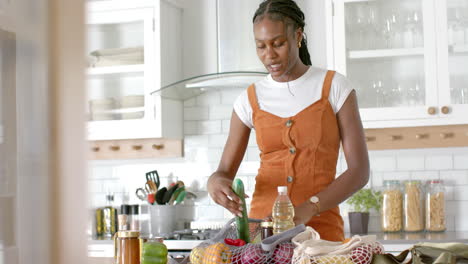 unpacking vegetables and bottles, woman preparing groceries in kitchen
