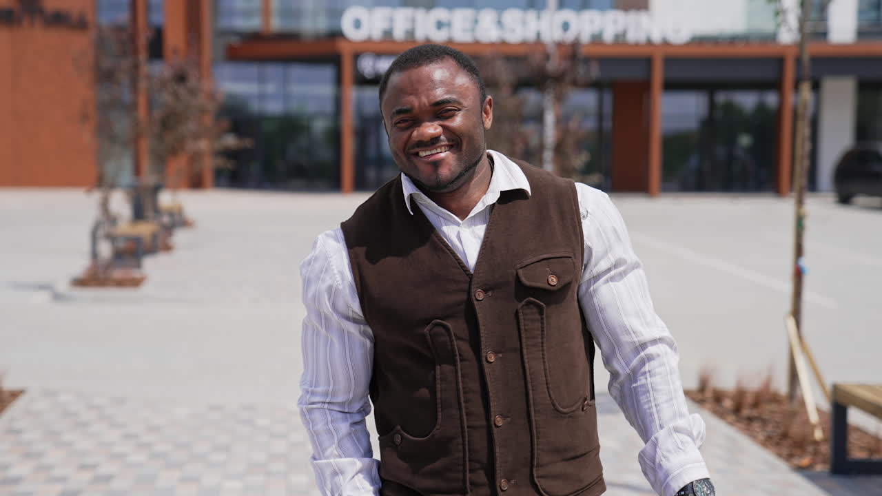 Portrait of a smiling african american man. Cheerful black guy looking at camera and putting on his glasses on urban background.
